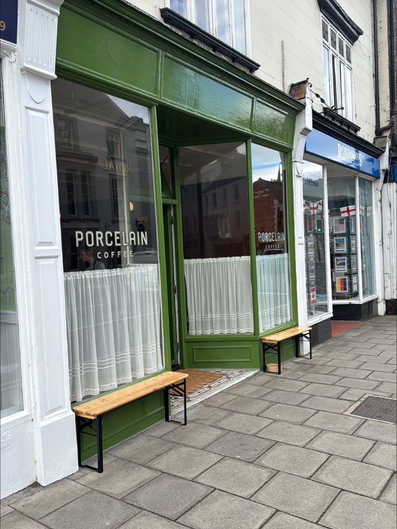 The benches under the shop window, café curtains behind the glass.