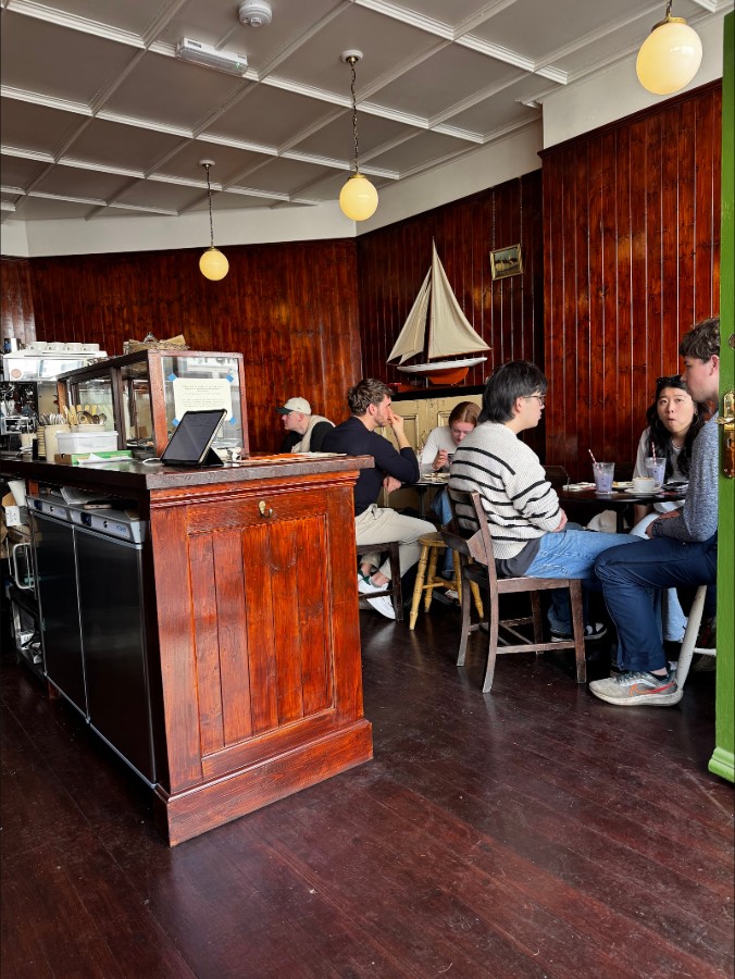 The room: customers at the tables under the model sailboat.